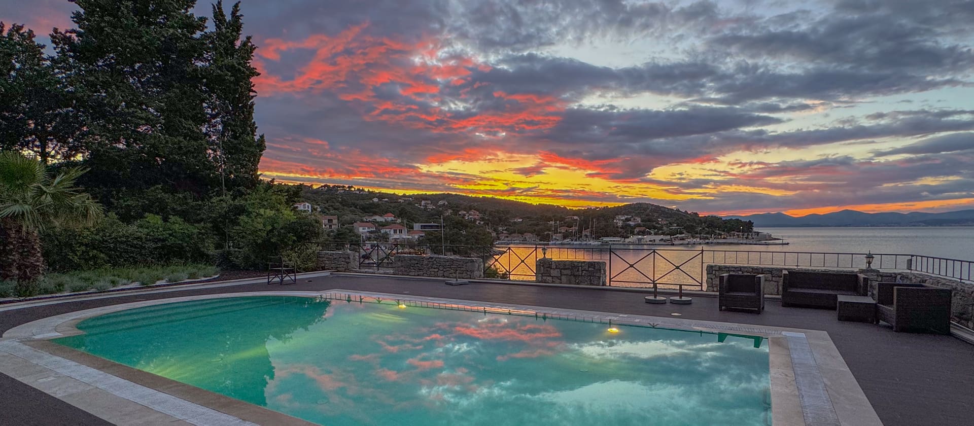 Der Pool spiegelt den dramatischen Abendhimmel